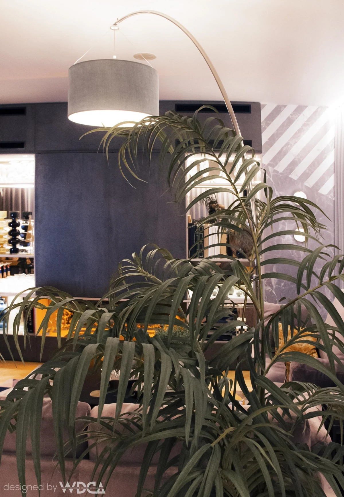 Indoor plants beneath an arc floor lamp