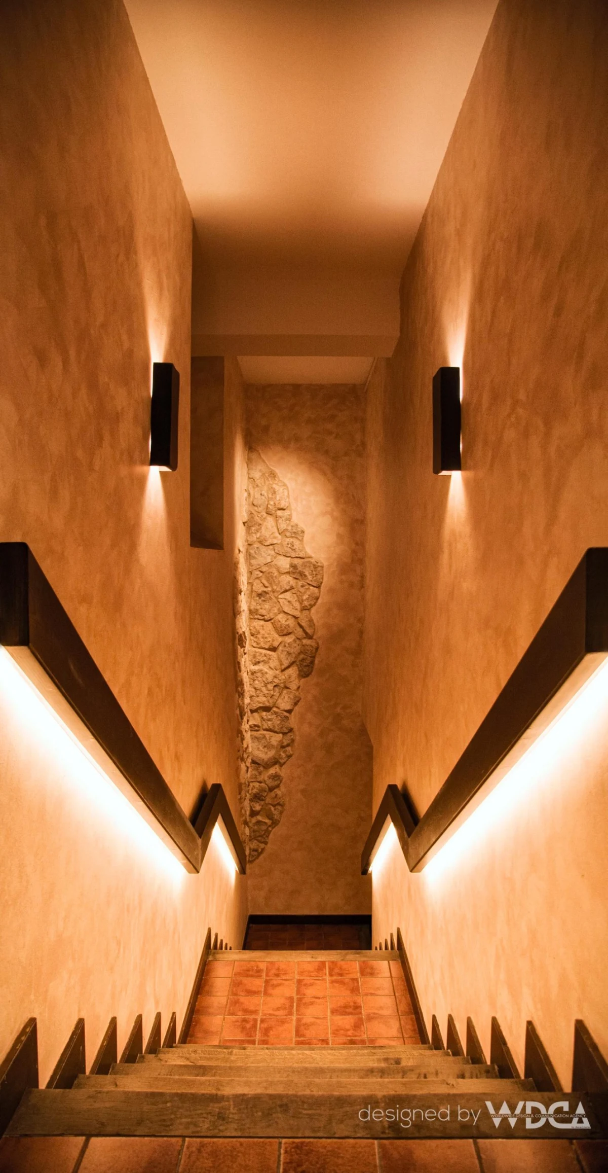 Pasillo de ladrillo y escalera iluminada
