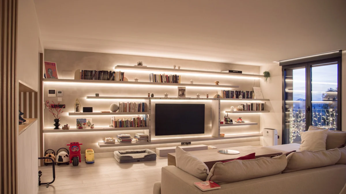 Salón de Casa JR con mueble de televisión y estanterías iluminadas