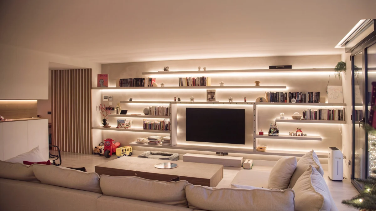 Salón de Casa JR con mueble de televisión y estanterías iluminadas