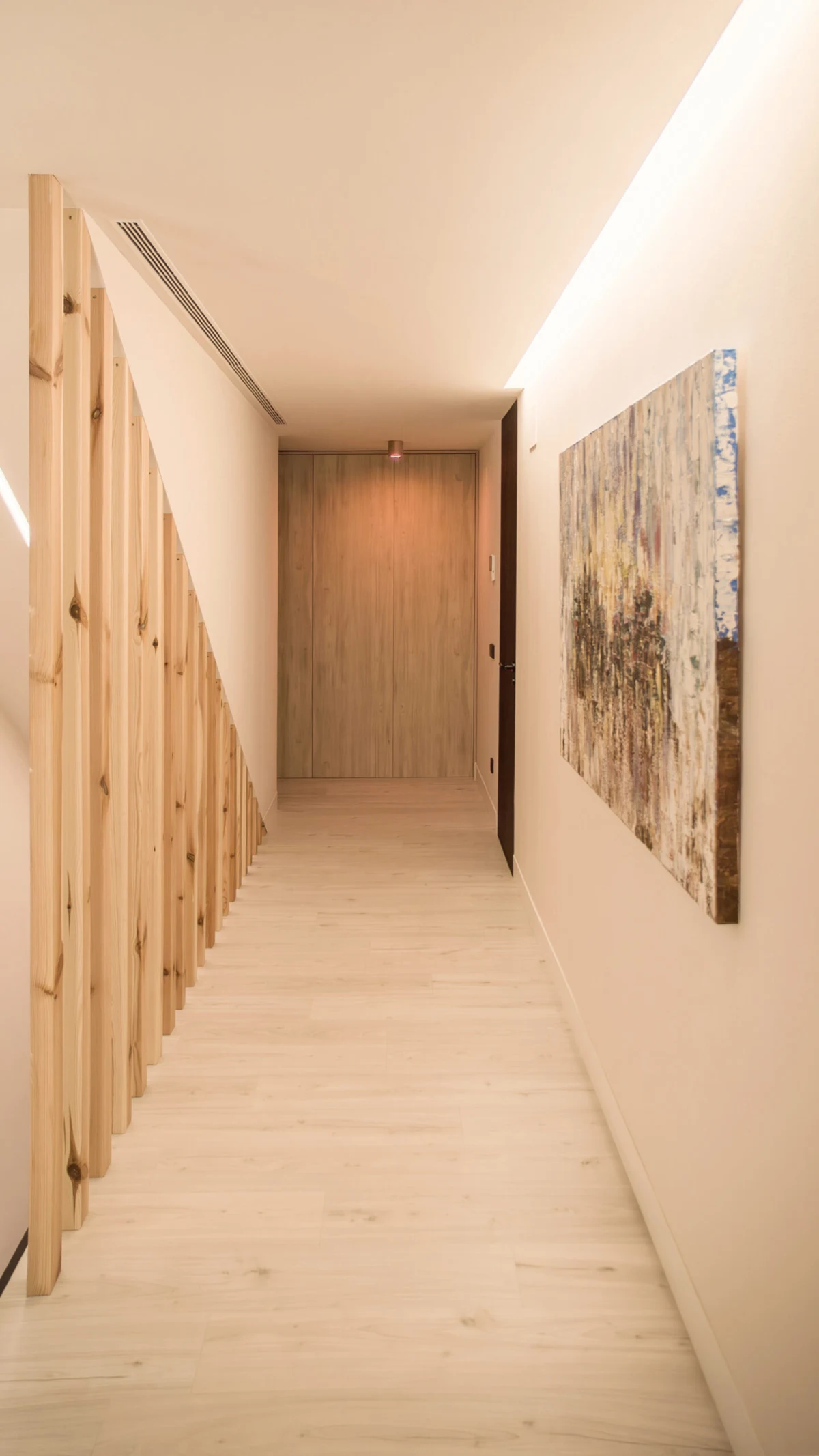 Pasillo de Casa JR con iluminación lineal cálida