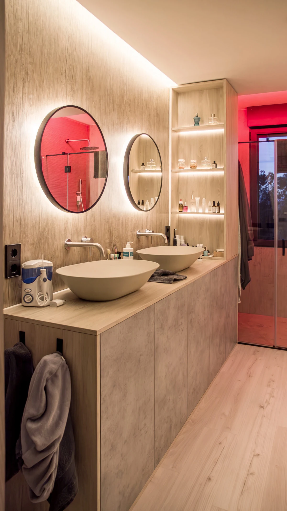 Baño de Casa JR con dos lavabos e iluminación de color en la ducha