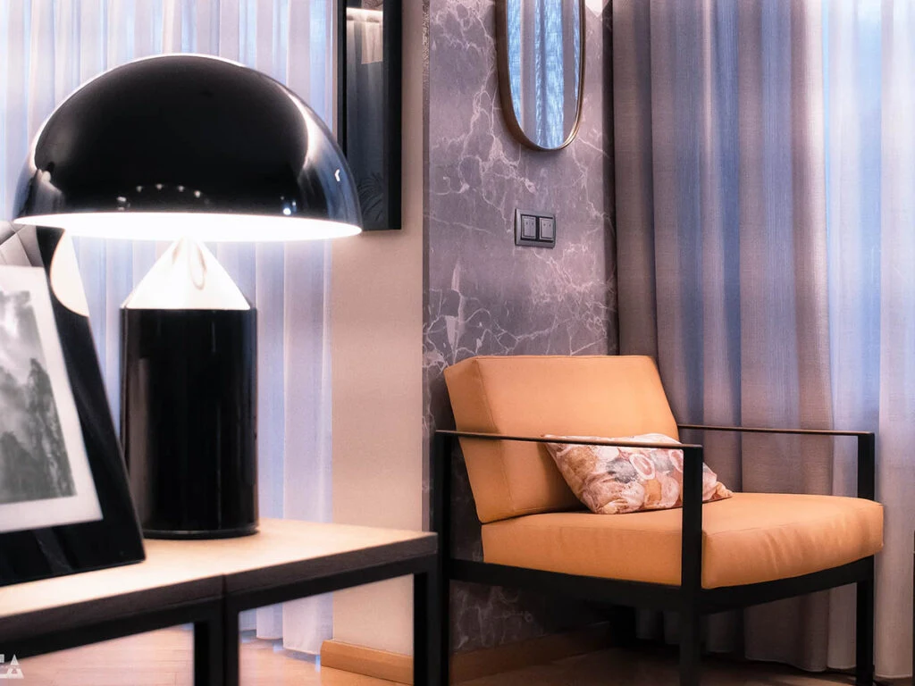 Living room with orange armchair and black dome lamp